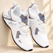 White and grey lace-up sneakers leaning on an ivory stone ledge