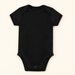 Plain black baby bodysuit on ivory surface