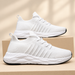 White fabric sneakers on neutral boxes against ivory background