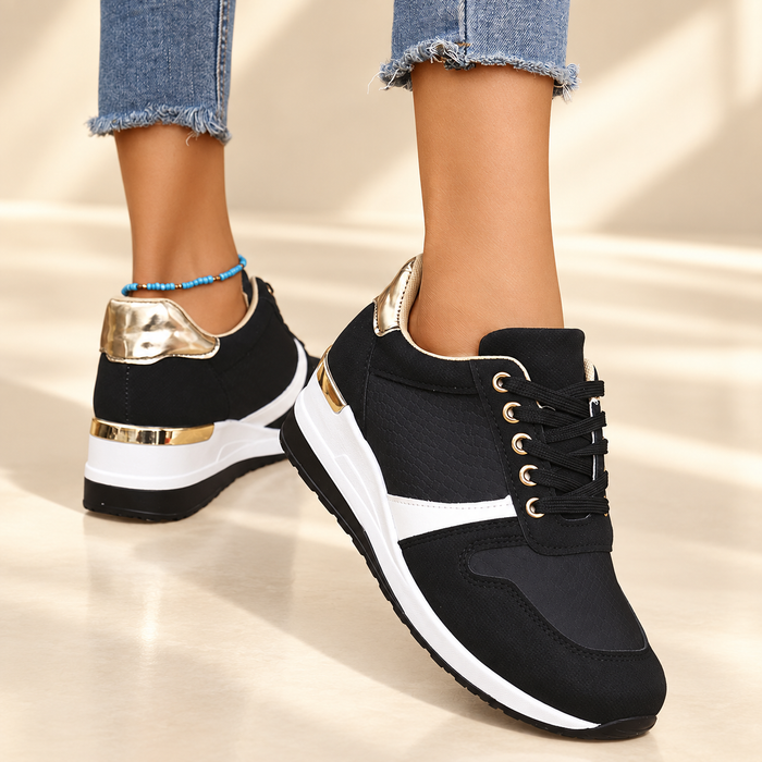Black gold and white sneakers worn against ivory background