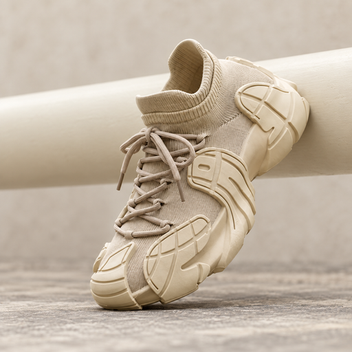 Beige knit sneaker with sculpted sole resting against a neutral rail.