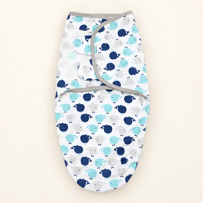 White baby swaddle with whale print on ivory background