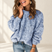Light blue textured knit sweater in a neutral fashion setting.