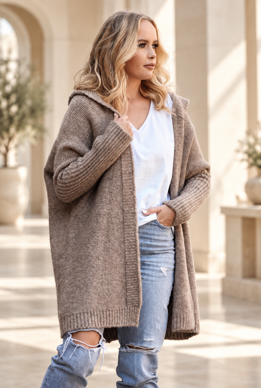 Taupe hooded knit cardigan worn over a white top and jeans in an ivory interior
